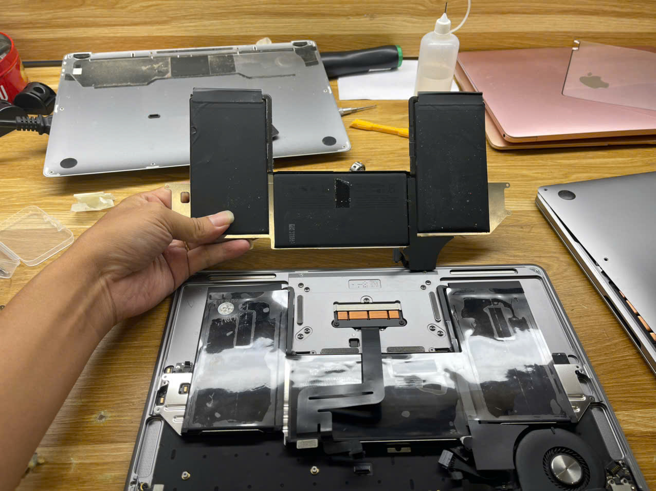 Bộ pin MacBook được tháo khỏi thân máy tại bàn kỹ thuật